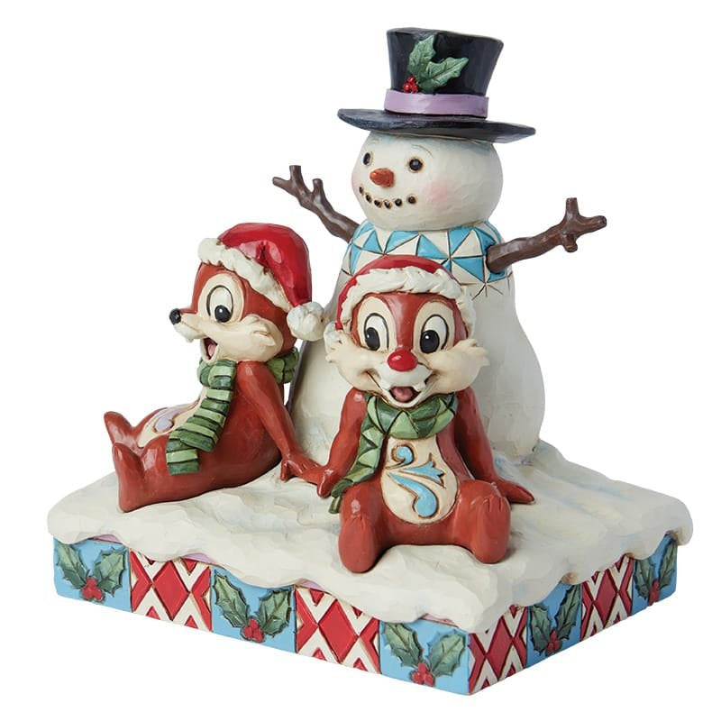 Sfeervolle kerstdecoratie met Knabbel en Babbel rond een sneeuwpop, perfect voor liefhebbers van Disney en traditionele kerstversiering.