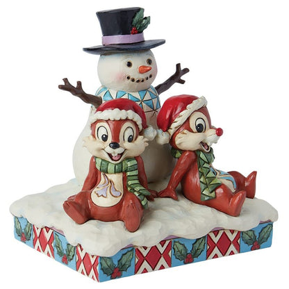 Detail van de handbeschilderde Disney Traditions kerstfiguur met Knabbel en Babbel, staand in de sneeuw naast een sneeuwpop, vol kerstmagie en nostalgie.